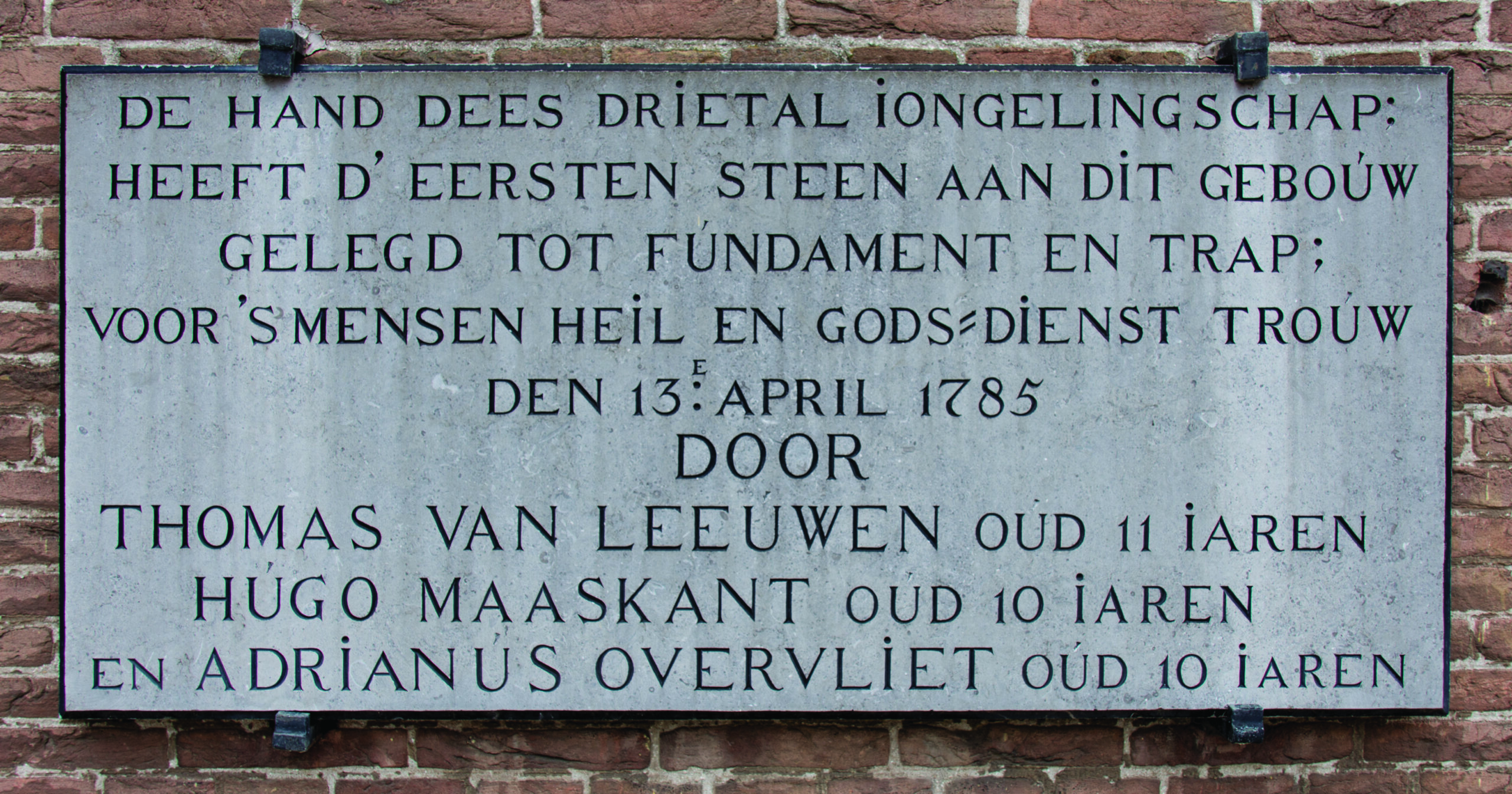 Eerste steen van de Oude Kerk in de Dorpsstraat (foto 2019), gelegd door Thomas van Leeuwen, Hugo Maaskant en Adrianus Overvliet