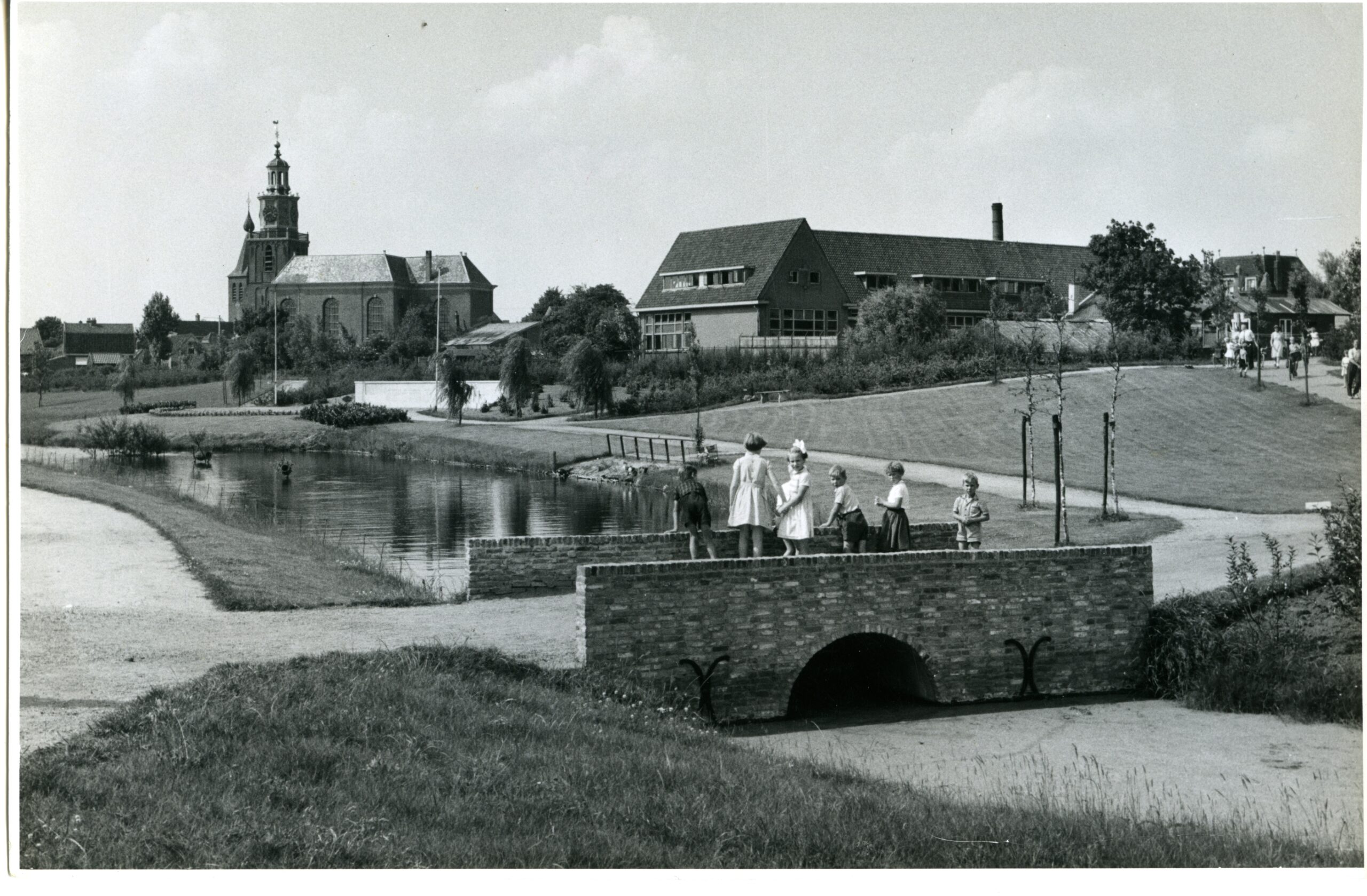 Kinderen op de brug in het Wilhelminapark; op de achtergrond de Oude Kerk en de Christelijke Lagere School aan de Dorpsstraat nr. 99.